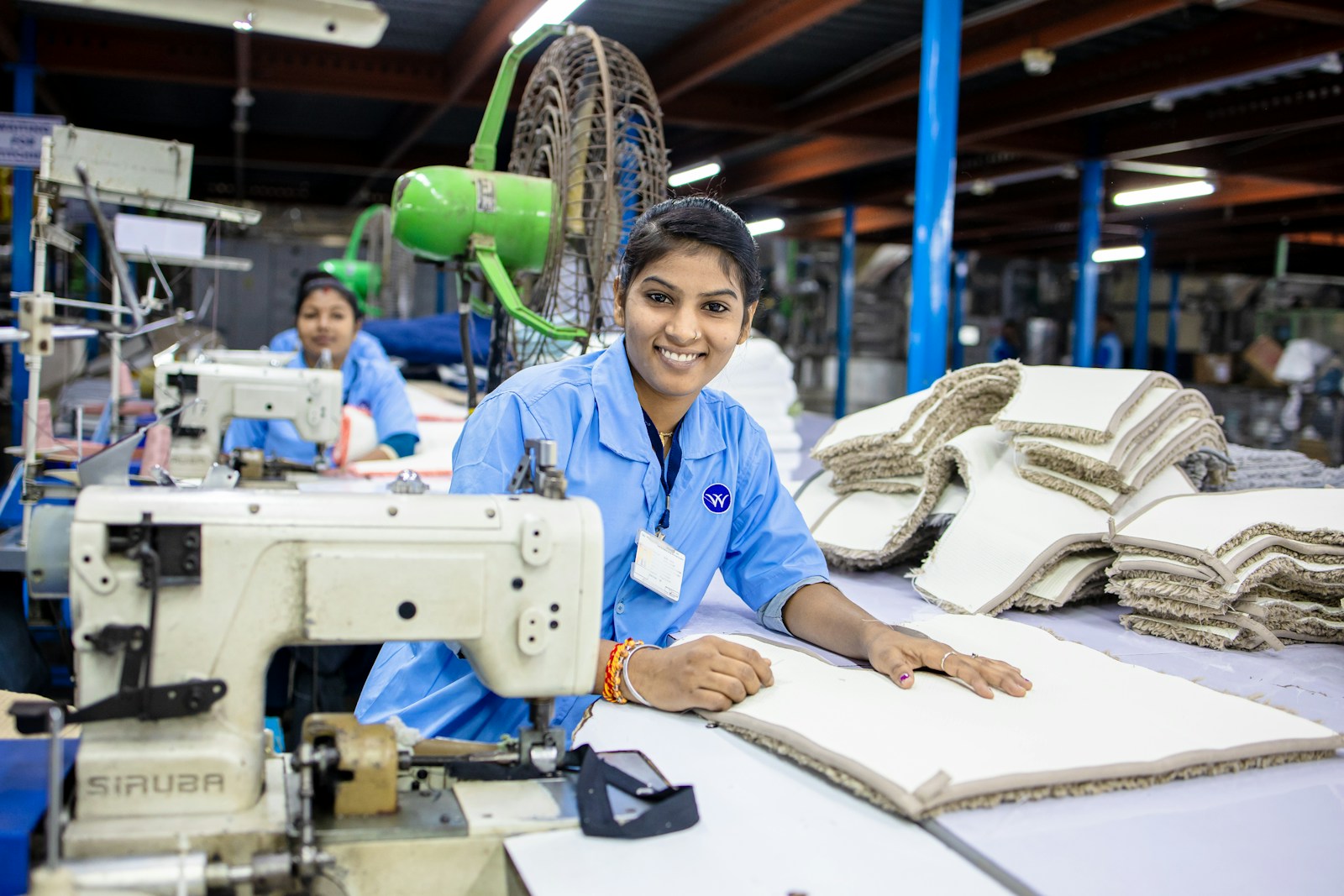 Factory workers sewing fabric together.