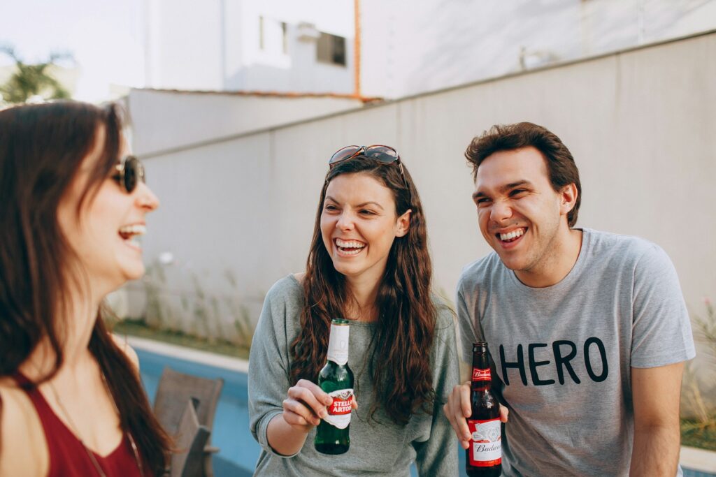 smiling woman holding coca cola bottle beside smiling woman holding coca cola bottle